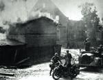 Niemiecka kolumna zmotoryzowana w płonącej polskiej wsi 