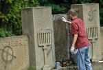 Licealiści sprzątają cmentarz żydowski w Częstochowie w 2007 r. Zmywają nazistowskie symbole namalowane na macewach