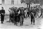 Członkowie Milicji Francuskiej, nacjonalistycznej bojówki wspierającej rząd Vichy, prowadzą więźniów, 1944 r. 