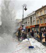 Odśnieżanie dachu obok przystanku na Nowym Świecie