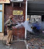 Brama przy Chmielnej 10. Wolontariusze uzbrojeni w myjki ciśnieniowe i szpachle walczą z graffiti i tonami naklejek. Za sprawą etatowego pracownika taki widok na Chmielnej już niedługo ma być codziennością   