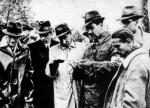 21 lub 22 maja 1943 roku. Józef Mackiewicz (w środku) w Lesie Katyńskim przegląda dokumenty zamordowanych (fot. Archiwum Kazimierza Orłosia)