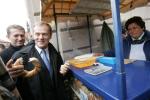 Donald Tusk kupuje tradycyjnego precla podczas swojej wizyty w Krakowie w październiku 2007 r.