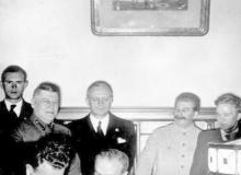 Wiaczesław Mołotow (podpisuje układ), za nim - Joachim von Ribbentrop, obok - Józef Stalin, 23 sierpnia 1939 roku Bigger