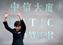 Citic Pacific mógł stracić na ryzykownych opcjach finansowych nawet  1,9 mld dol. Na zdjęciu: ochroniarka próbująca przegonić fotoreporterów sprzed siedziby firmyBigger