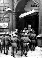 Milicjanci wchodzą  13 grudnia  1981 roku  do siedziby Zarządu Regionu „Solidarności” Ziemi Łódzkiej. Poszukujemy autora tego zdjęcia,  a także innych, niepublikowanych dotąd fotografii z okresu stanu wojennego. Zdjęcia te można obejrzeć na stronie  <a href=