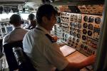 Kokpit samolotu Tu-154. Na pierwszym planie nawigator, za nim technik. W głębi drugi pilot maszyny.