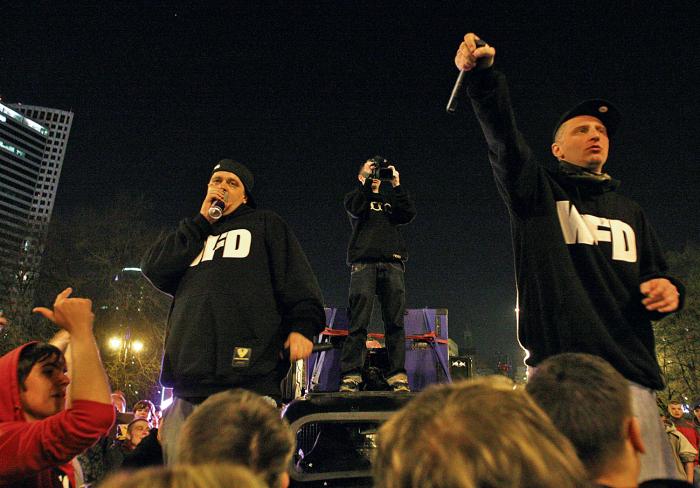 Tede  (po lewej) podczas spontanicznego koncertu Warszafskiego Deszczu pod PKiN.  Po prawej Numer Raz  