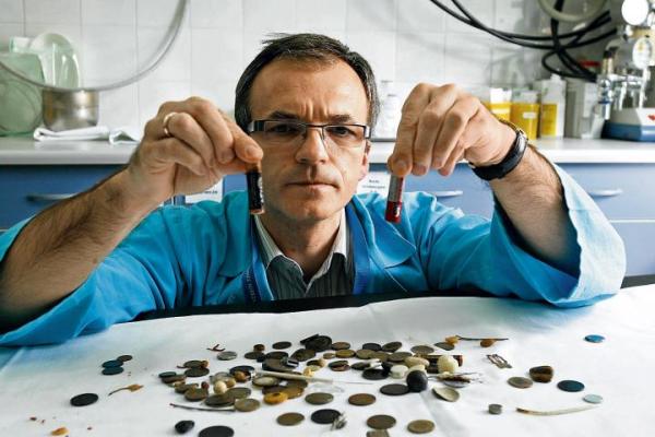 Docent Marek Woynarowski prezentuje kilkadziesiąt baterii i monet, które połknęli mali pacjenci. Zatrzymał je na pamiątkę i ku przestrodze rodziców