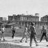 *1947 rok.  Rozgrywki siatkówki na pl. Zwycięstwa. W tle, po prawej, wypalony  gmach Hotelu Europejskiego. Mury trzymają się mocno