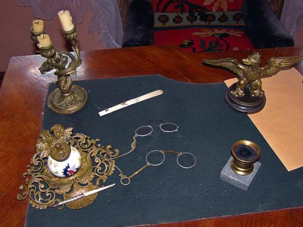 Na biurku charakterystyczne binokle oraz przycisk do papieru z symbolem orła