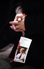 Prezes PiS Jarosław Kaczyński ze zdjęciem brata Lecha Kaczyńskiego podczas mszy dziewięć miesięcy po katastrofie samolotu prezydenckiego pod Smoleńskiem