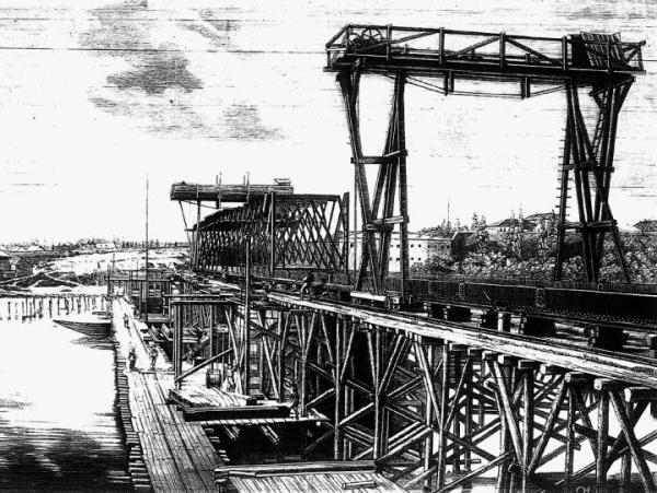 Wspaniała  grawiura  z tygodnika „Kłosy” (1874 r.) przedstawiająca budowę pierwszego mostu kolejowego; widok od strony Pragi. W tle  – Cytadela  z tzw. kaponierą południową,  a po lewej  – fragmenty opuszczonych fortyfikacji ziemnych