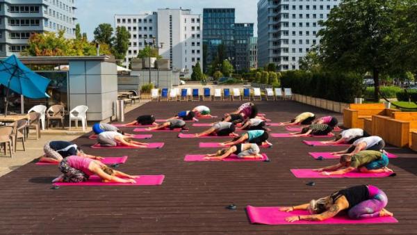 Letnie lekcje jogi są organizowane na placu między budynkami Empark Mokotów Business Park w Warszawie.